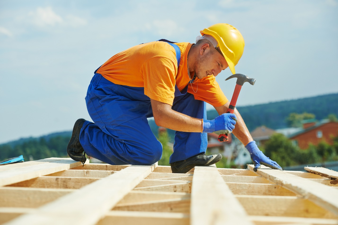 A person wearing a hard hat and working on a roof

Description automatically generated with low confidence